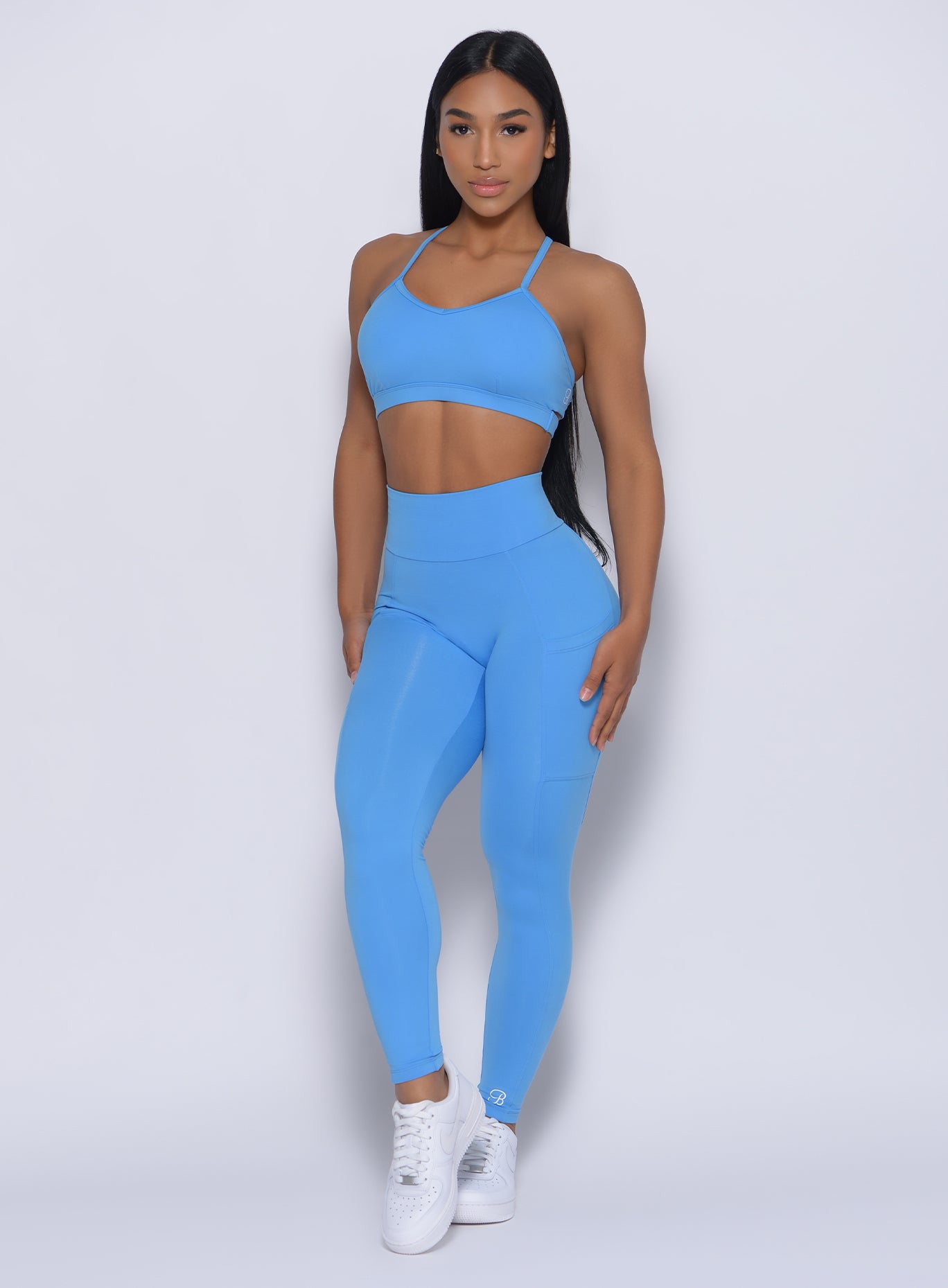 Front profile view of the model wearing our curves leggings in blazing blue color and a matching bra