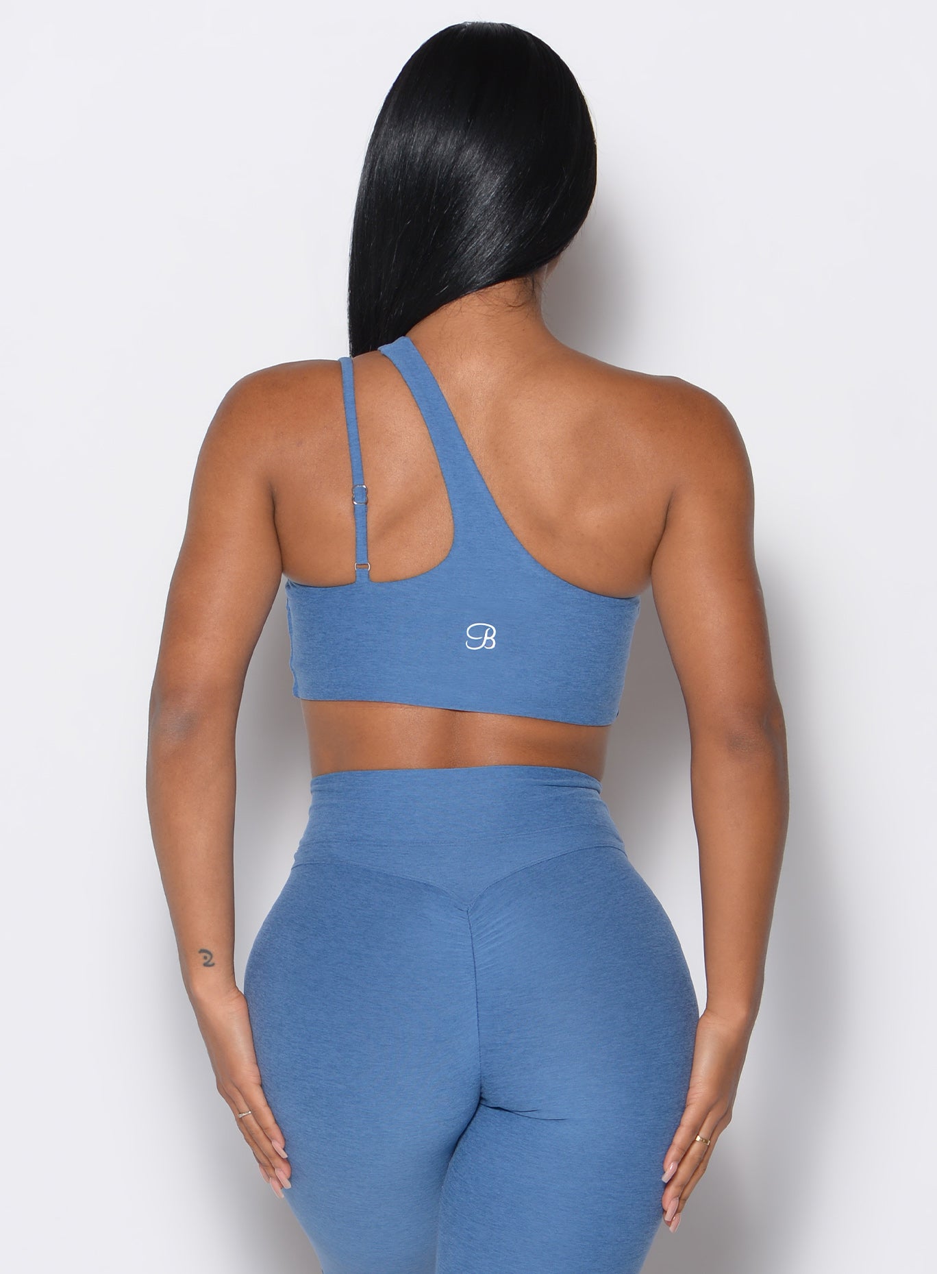 Back side close up view of model wearing the Lateral Top and the matching leggings in Chambray color