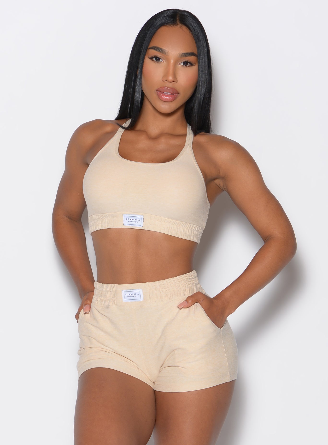 Front profile view of our model wearing the Cloud Lounge Bra in vanilla with both her hands in the pockets of the matching shorts