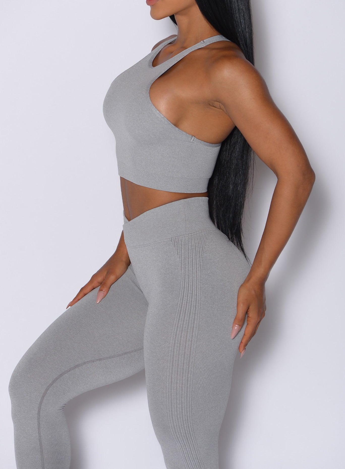 Left side close up view of a model wearing the Contour Seamless Leggings and the matching Lifter Heather Seamless Bra in Silver Mist color