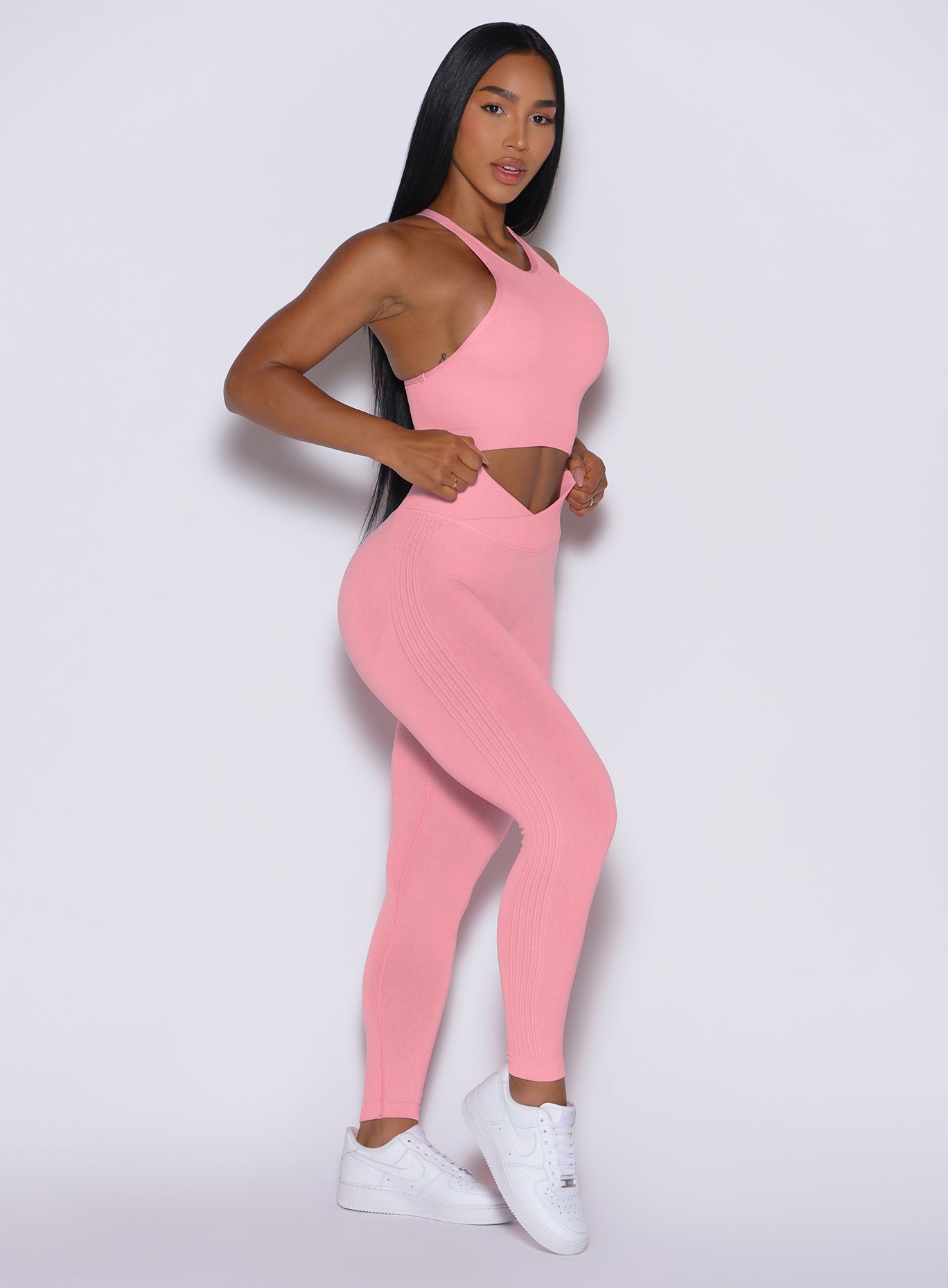 left profile view of a model facing to her left in our Contour Seamless Leggings and the matching Lifter Heather Seamless Bra in Ballerina color