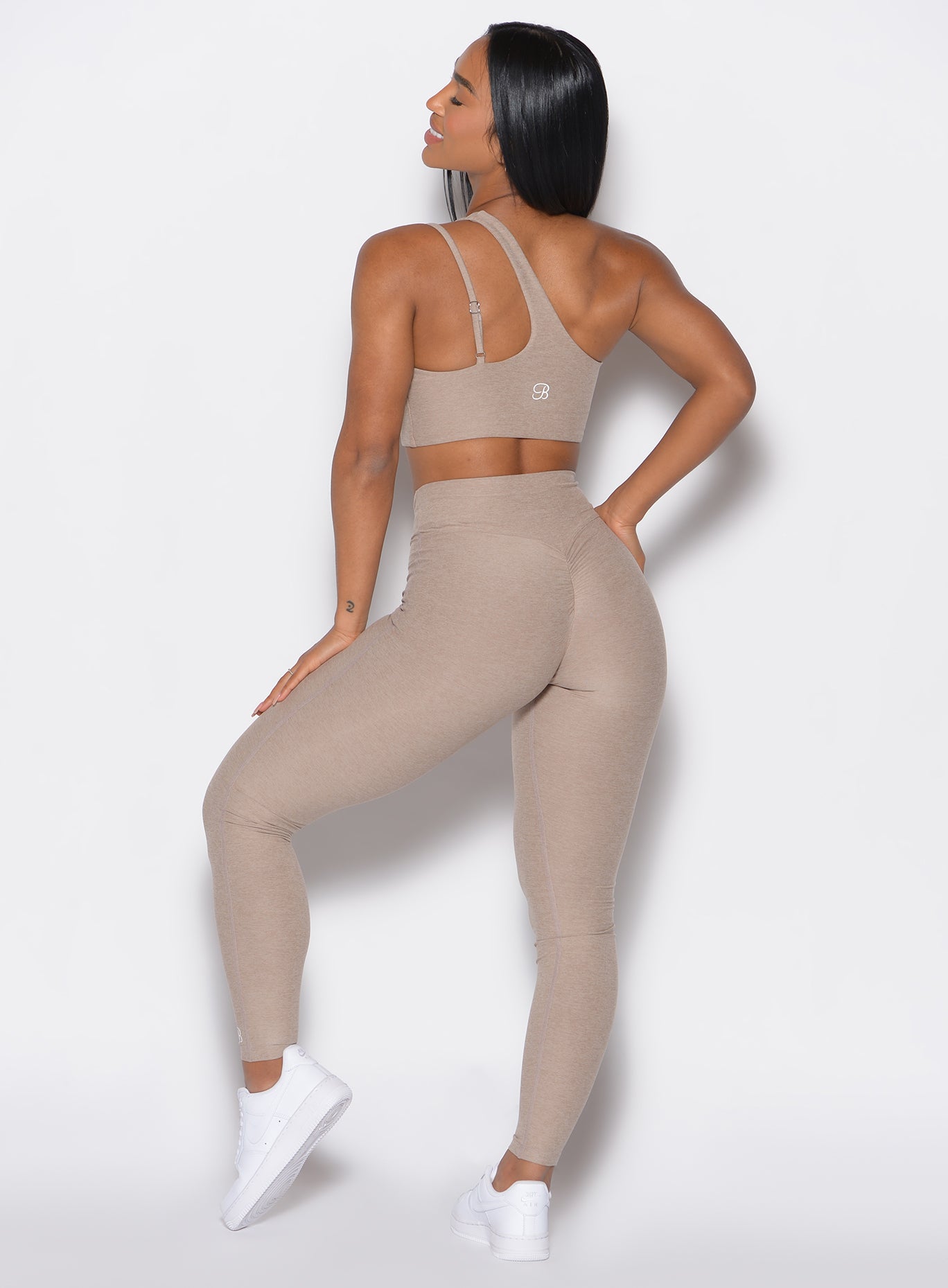 back profile of a model wearing the V Active Leggings and the matching Top in Desert Taupe color